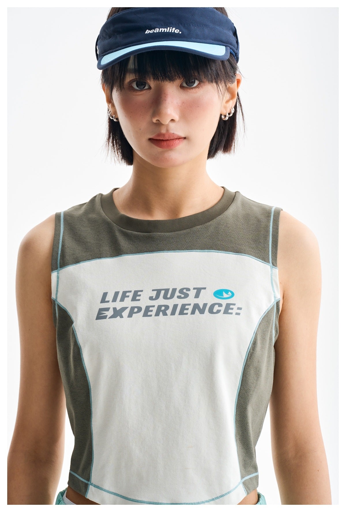 Close-up front view of a color-block sleeveless crop top with aqua piping and English chest lettering.