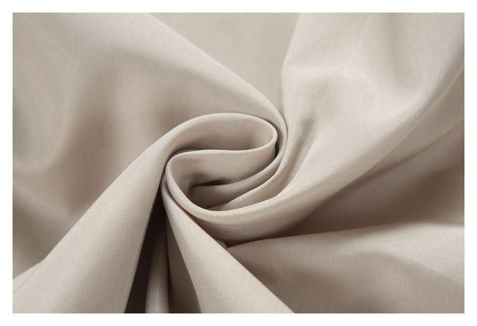Light beige fabric gathered into a soft spiral fold, showing its smooth drape.