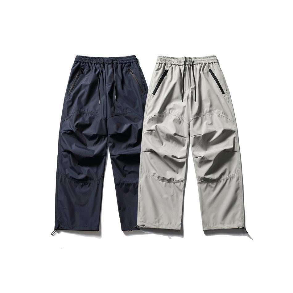 Two pairs of loose-fit cargo pants shown from the front in dark navy and light gray.