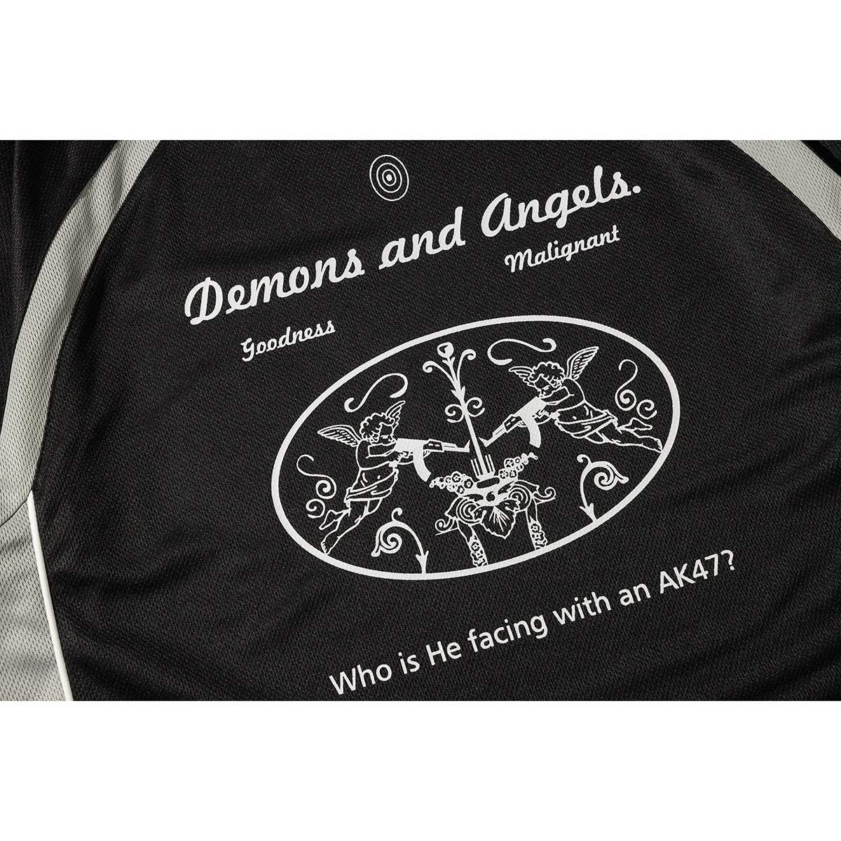 Close-up of white English lettering and an illustrated design printed on a black jersey.