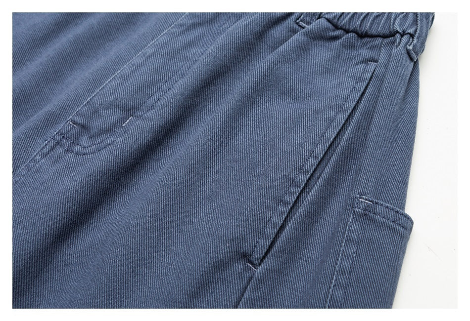 Close-up of blue pants showing a side seam and large side pocket against a white background.