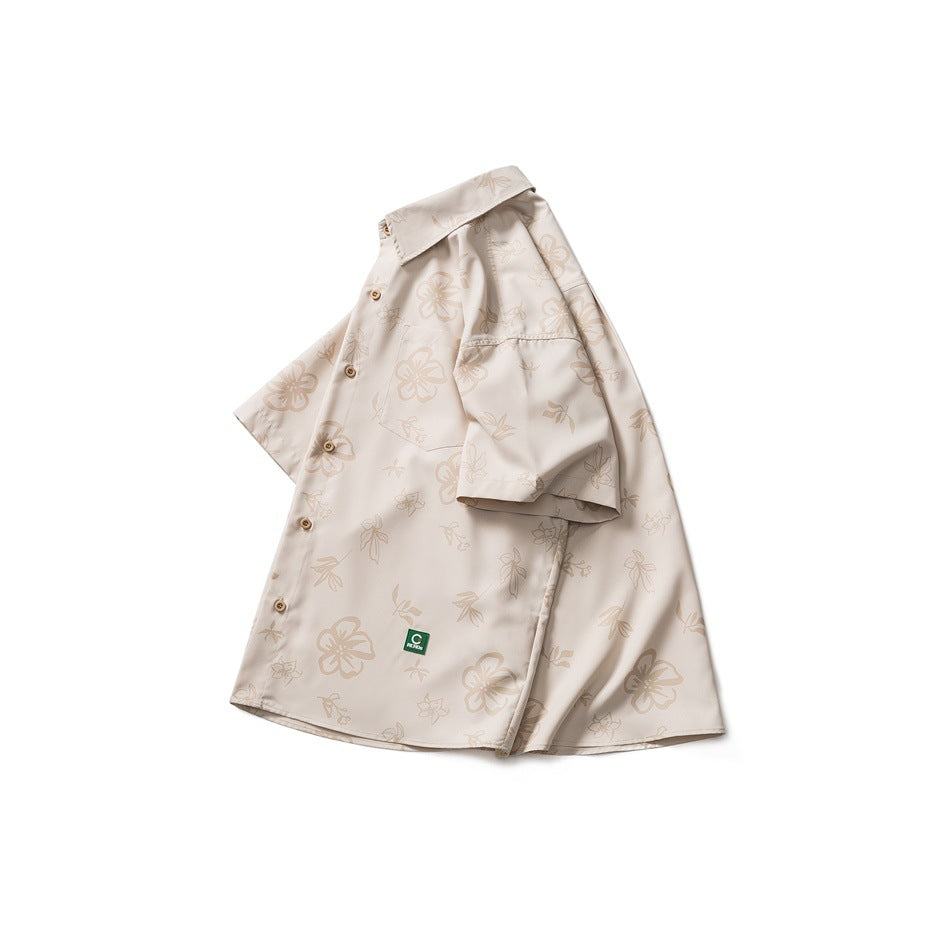Front view of a short-sleeved beige button-up shirt with a light floral print and chest pocket.