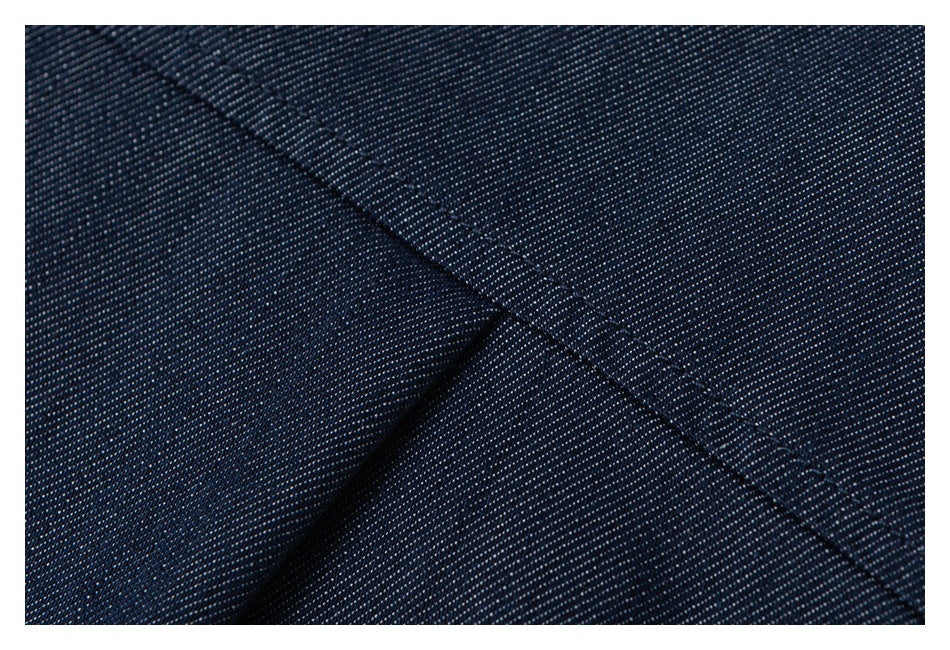 Close-up of a diagonal stitched seam across textured dark navy fabric.