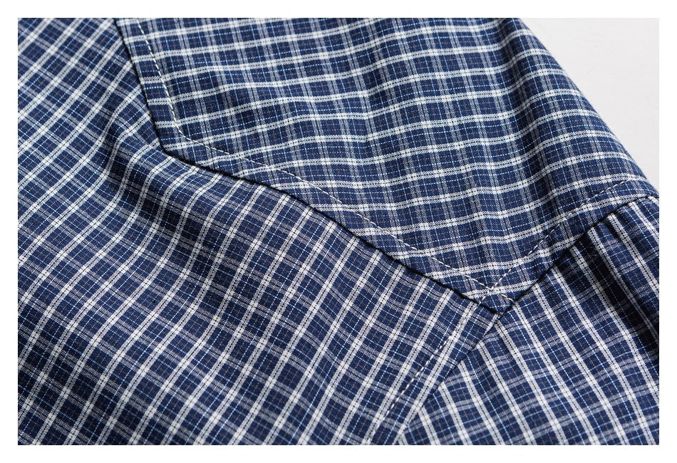 Close-up of the blue-and-white plaid shirt's stitched shoulder seam.