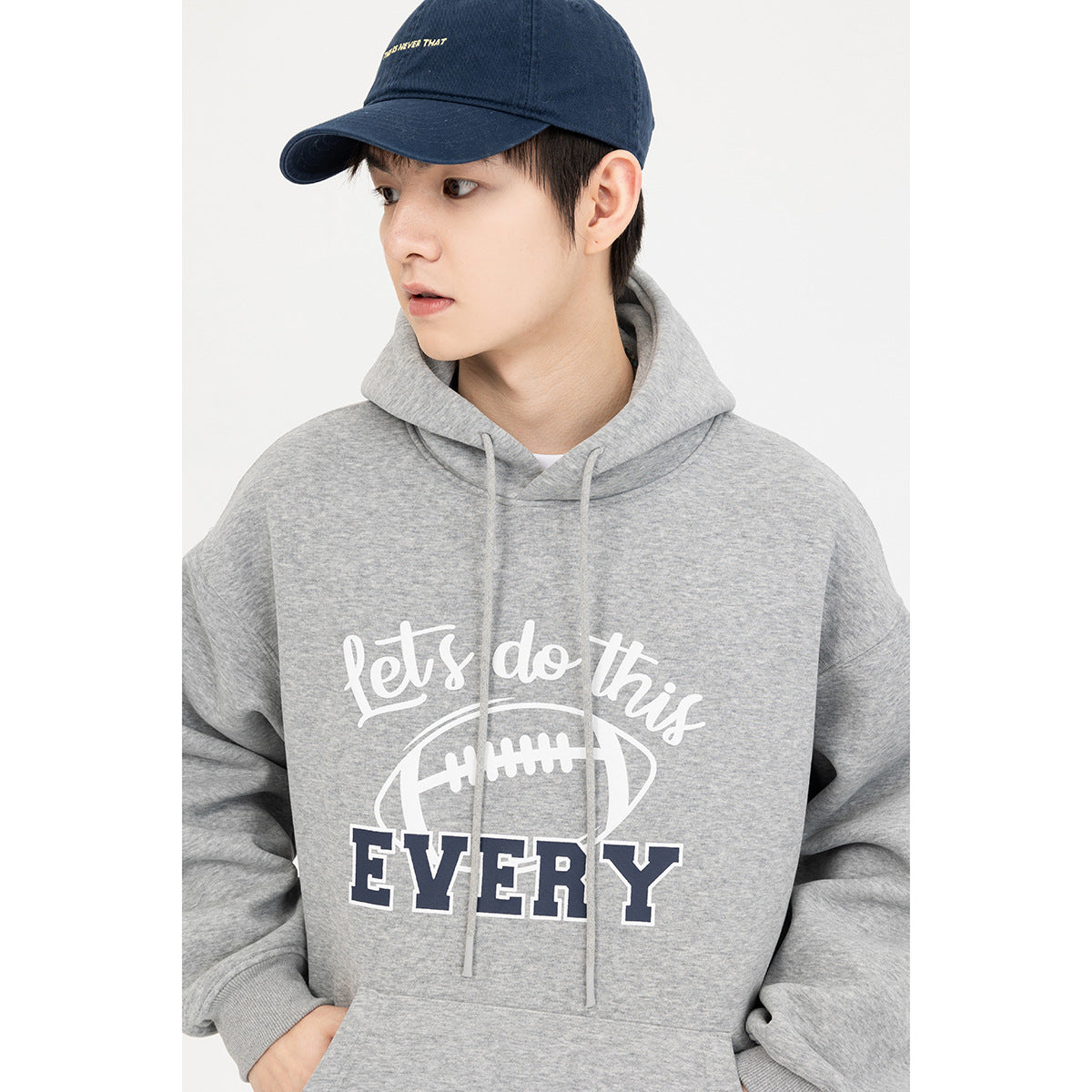 Model wearing a gray hoodie with drawstrings, a football graphic and “Let's do this EVERY” text.