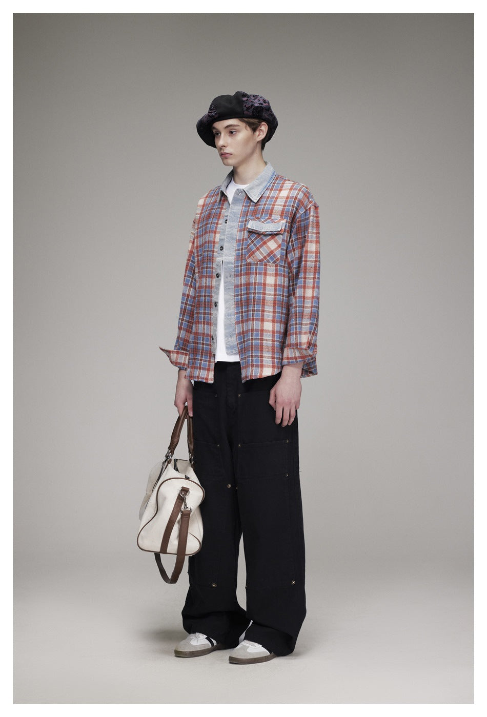 Model wearing a rust, blue and cream plaid button-up shirt with a light denim collar and a chest pocket.