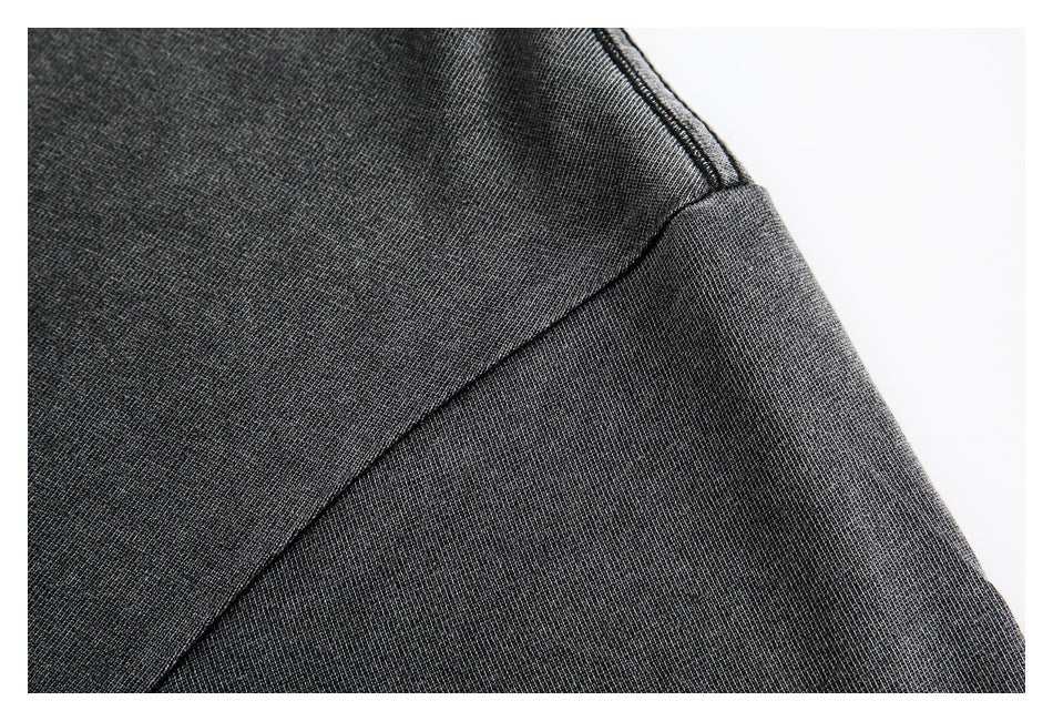 Close-up of a charcoal sweatshirt sleeve seam and textured fabric.