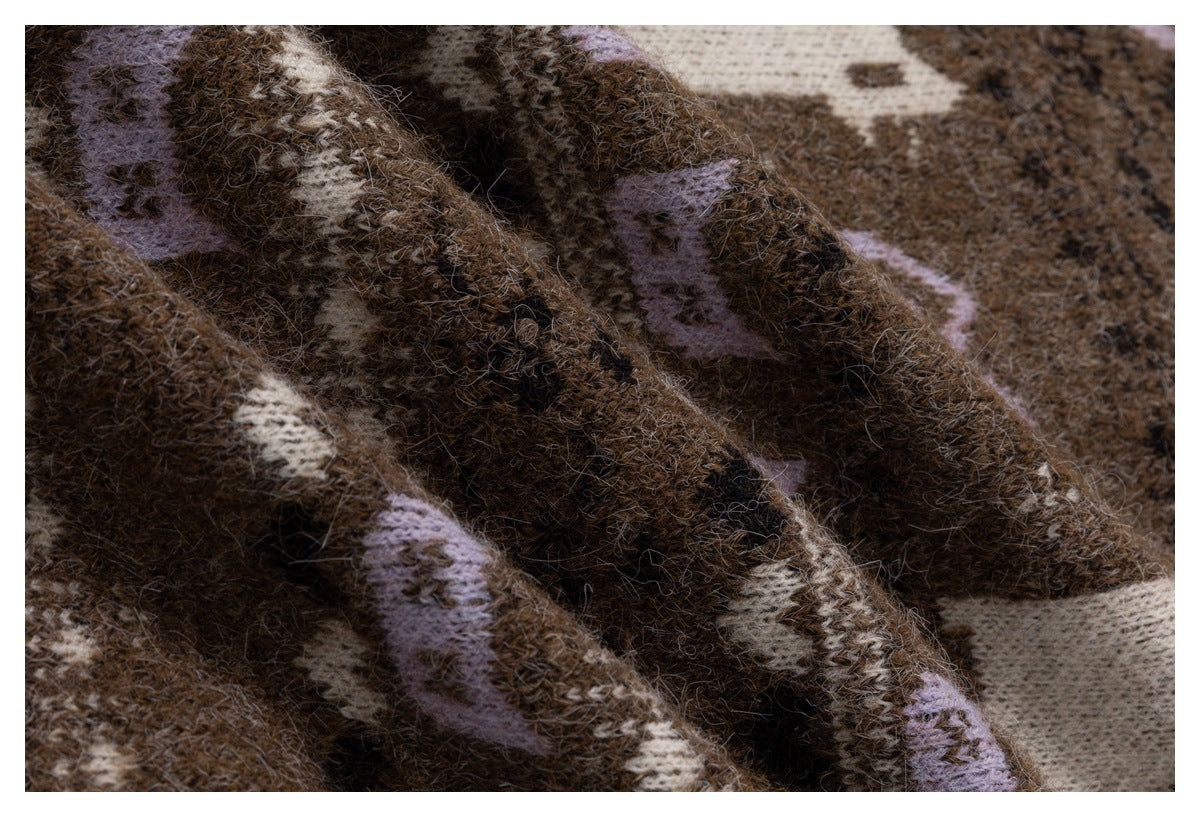 Close-up of fuzzy brown knit fabric with cream and lavender geometric patterns.
