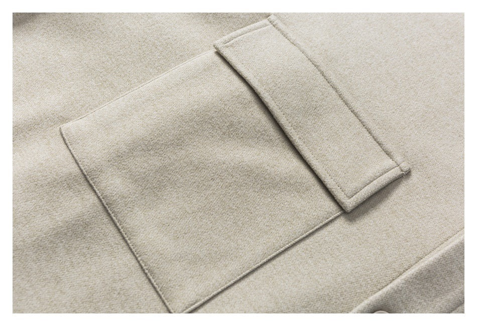 Close-up of a beige woven garment showing a large patch pocket and its narrow flap.