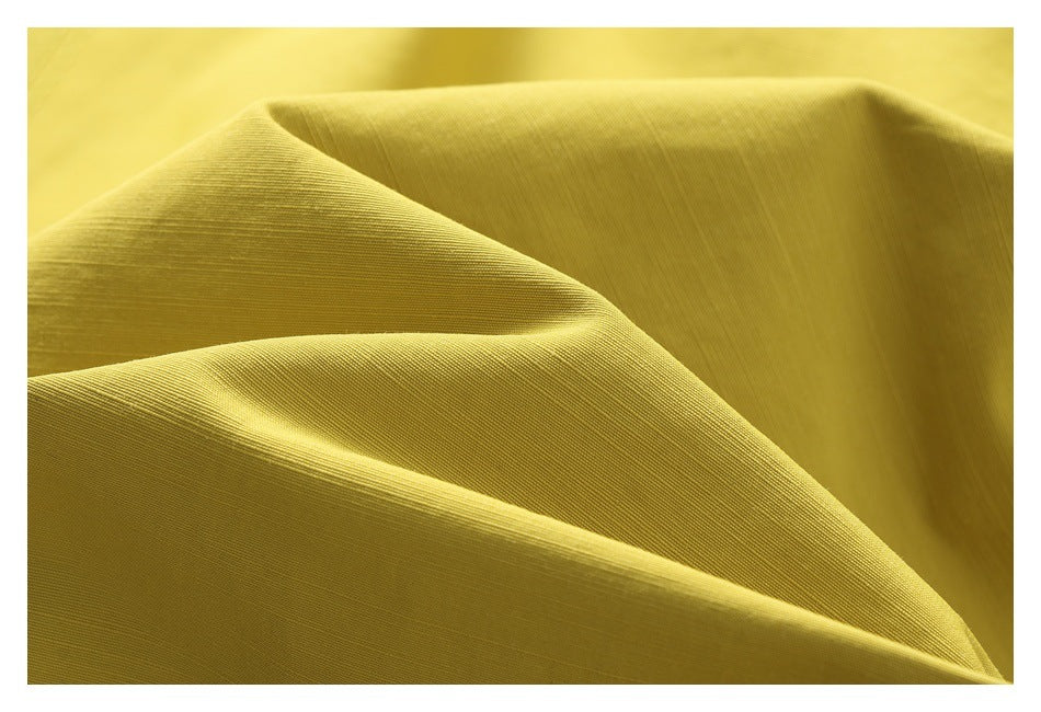 Close-up of yellow jacket fabric folded to show its fine surface texture.