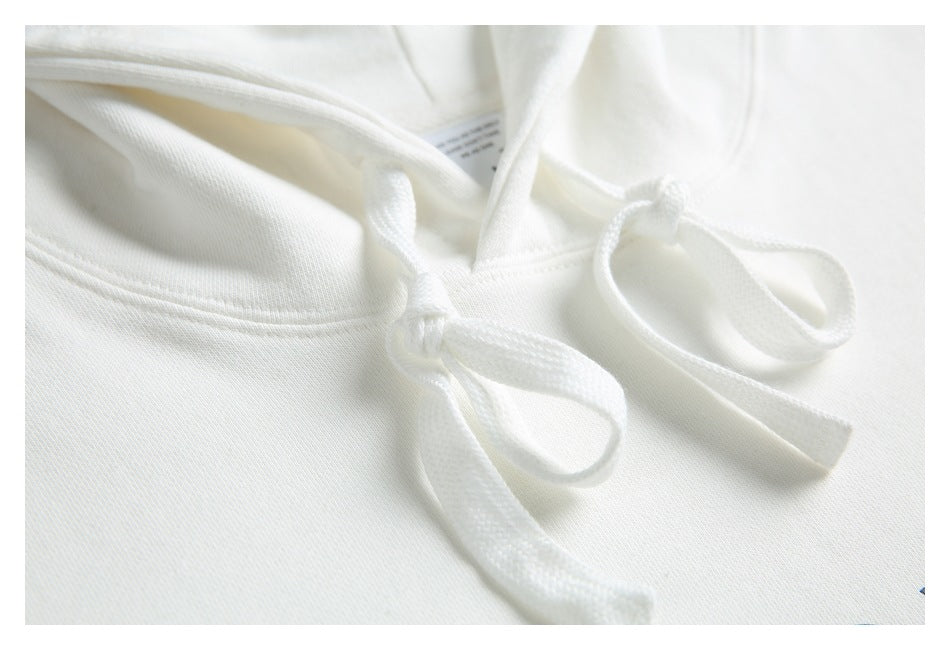 Close-up detail of white hoodie drawstrings, hood seams, and fabric.