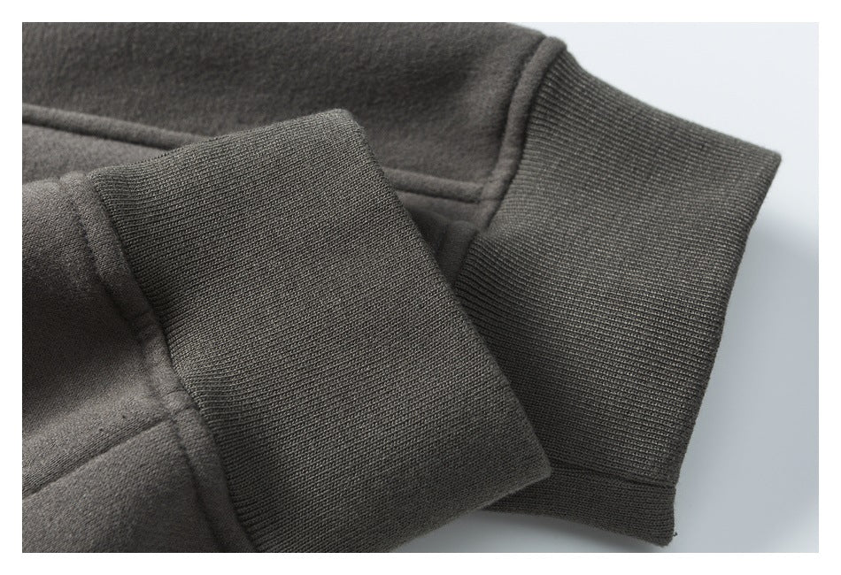 Close-up of a dark charcoal garment sleeve with a wide rib-knit cuff.