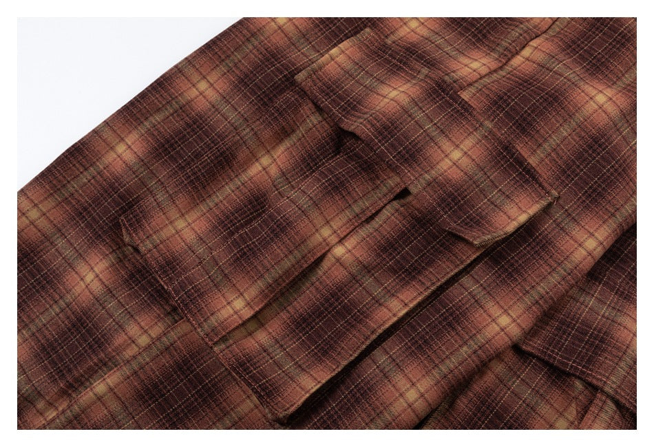 Close-up of a flap pocket on brown and tan plaid trousers.