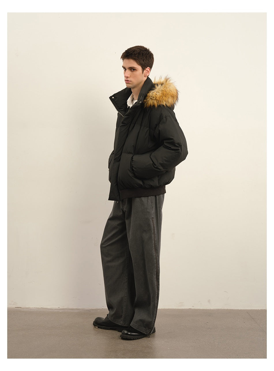 Side view of a model wearing a black fur-trimmed hooded puffer jacket with gray wide-leg trousers.