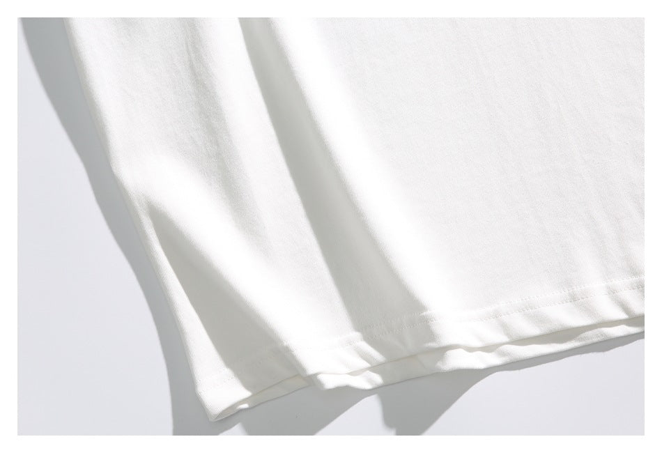 Close-up of the stitched hem on a white shirt laid flat.