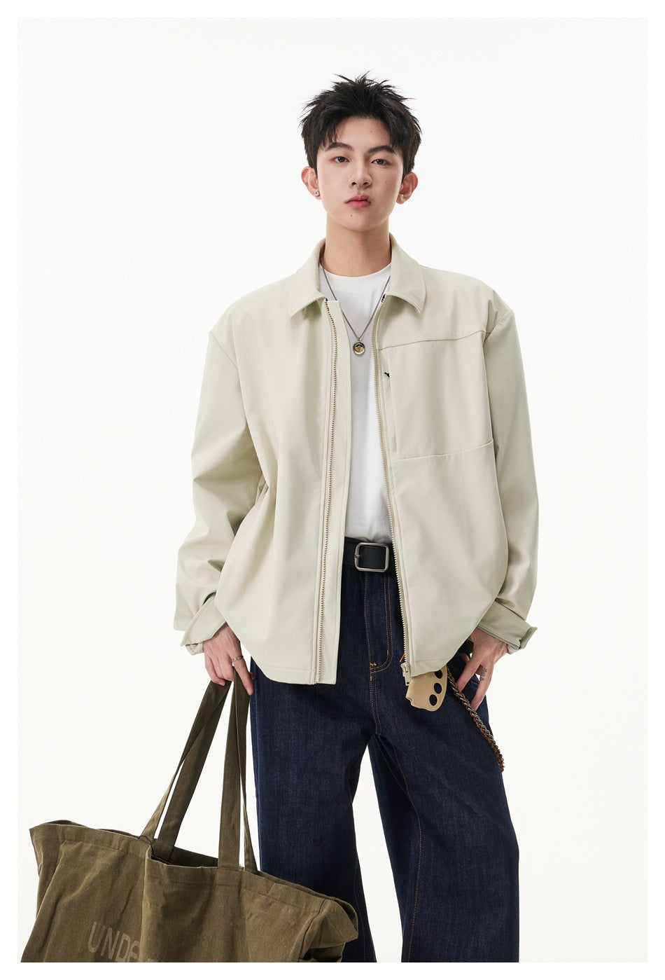 Model wearing an open ivory zip-front jacket with a pointed collar and chest panel over a white shirt.