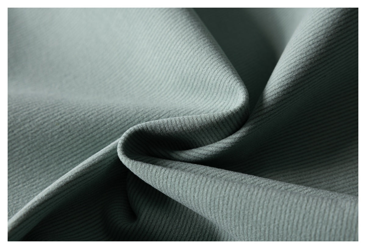 Close-up of sage-gray ribbed fabric softly folded to show its fine raised texture.