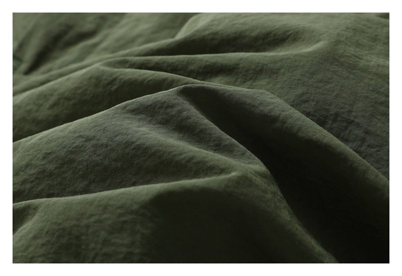 Macro view of dark olive garment fabric showing its surface texture and folds.