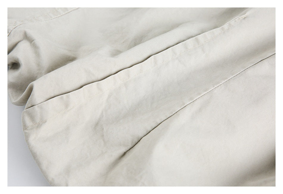 Close-up of a long stitched seam and folded edge on cream fabric.