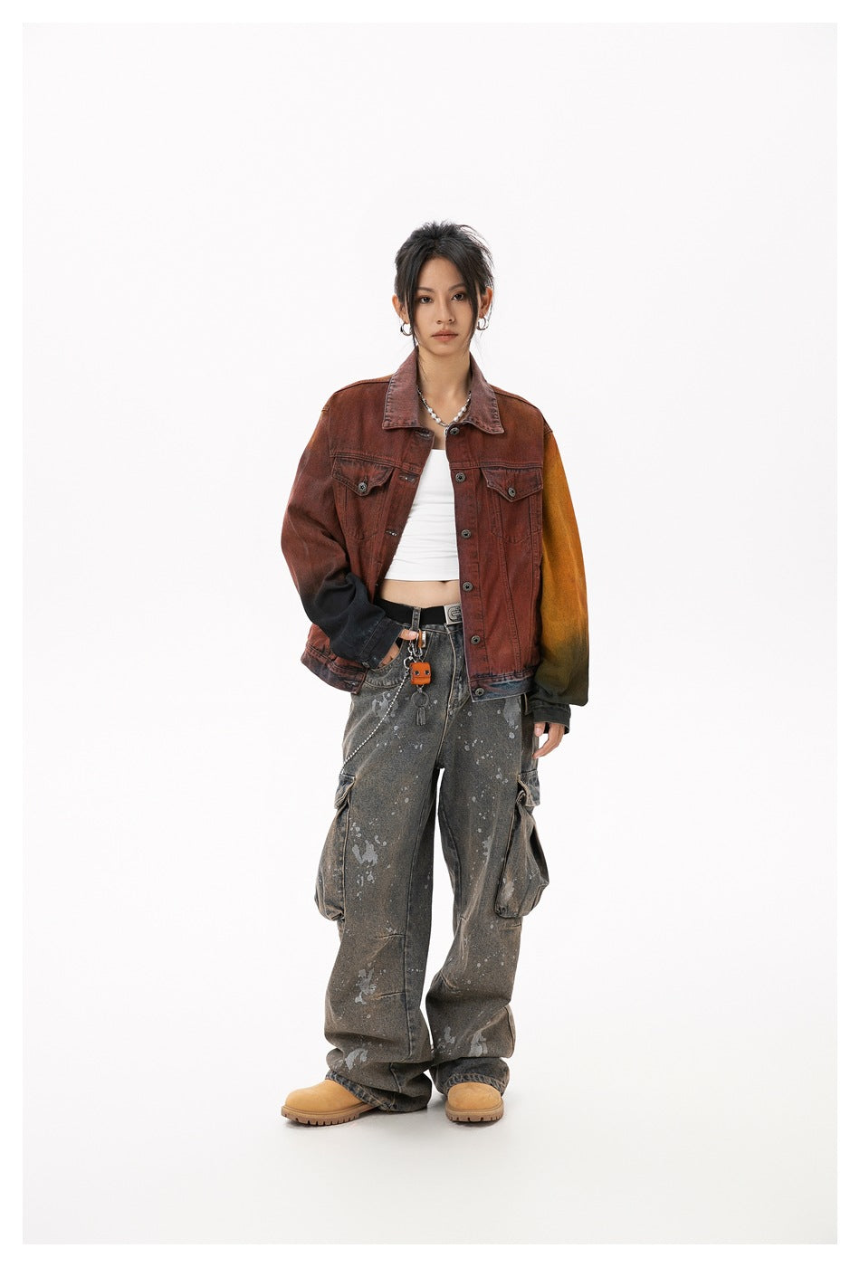 Front view of a model wearing a rust-red washed denim jacket with contrasting sleeves and loose gray cargo jeans.