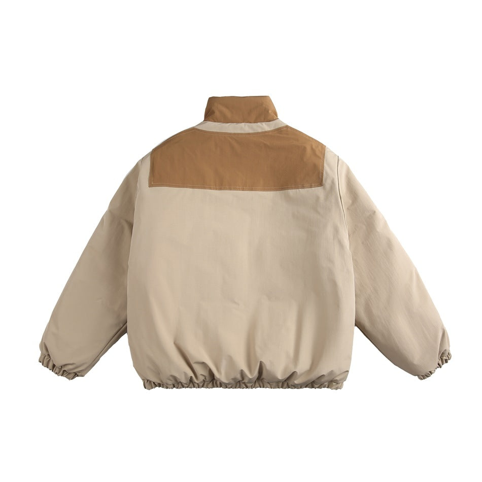 Back view of a beige jacket with a brown shoulder yoke, stand collar, and gathered cuffs and hem.