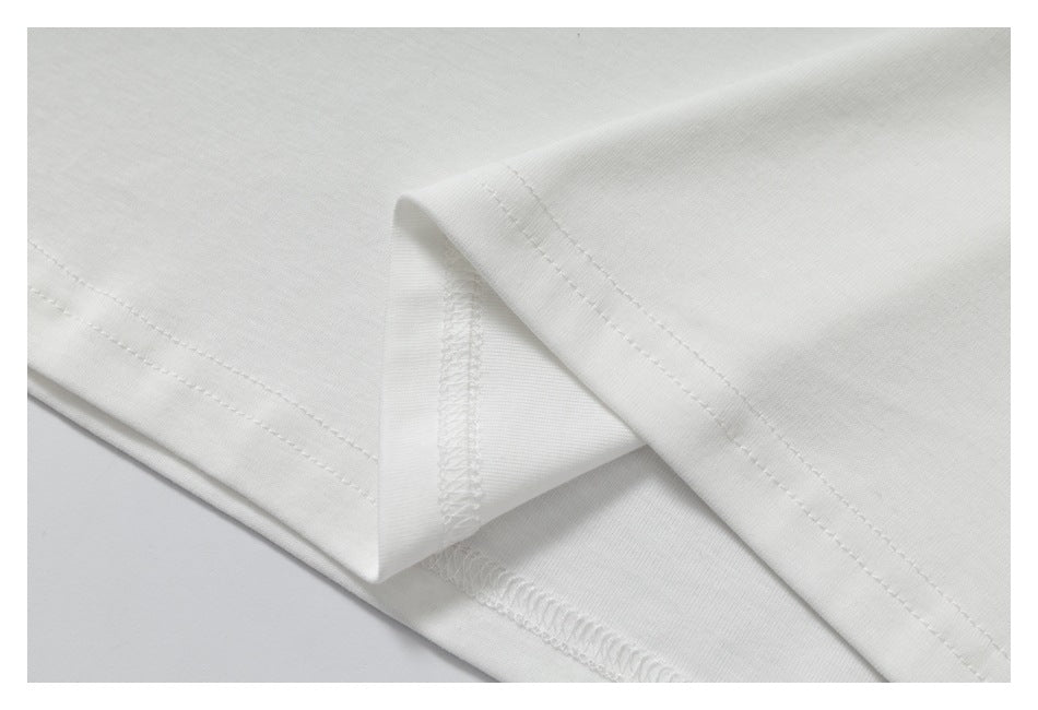 Close-up of the white shirt's folded hem and overlocked seam.