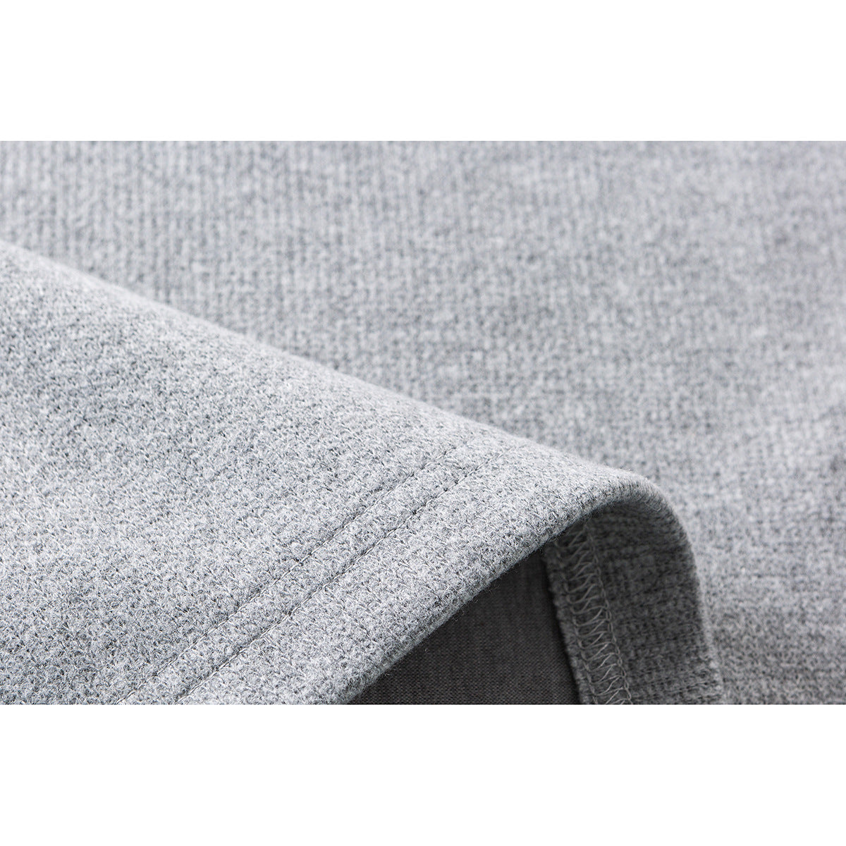 Close-up of a light gray garment edge showing stitching and an overlocked seam.