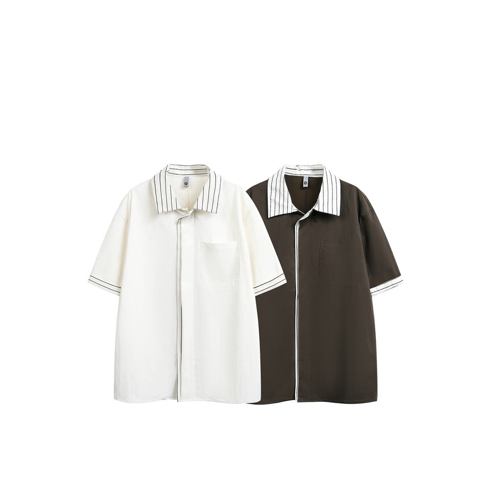 Two short-sleeve button-up shirts shown side by side in ivory and dark brown, both with striped collars and cuff trim.