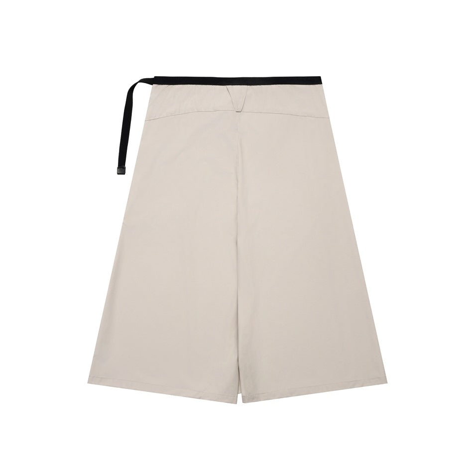 Light beige A-line wrap skirt shown flat, with a black waistband and long side tie.