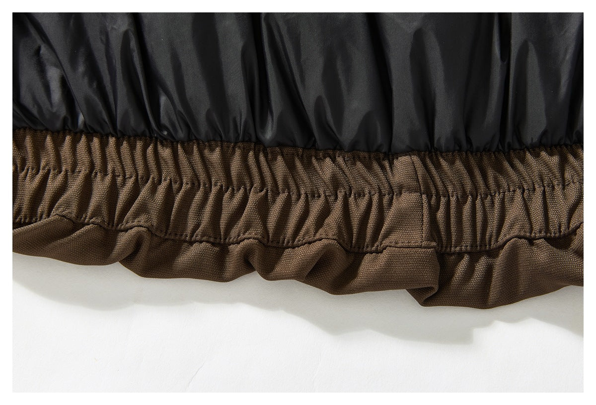 Close-up of black lining above the gathered brown hem of a garment.