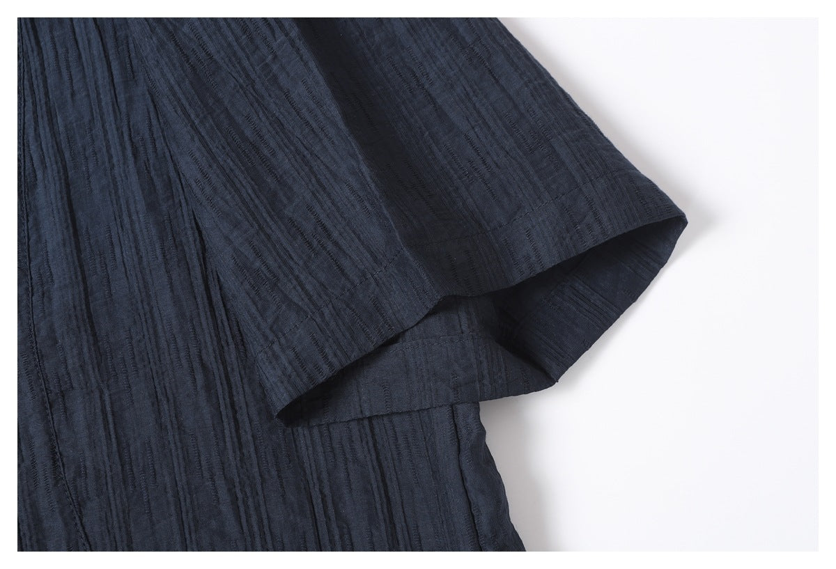 Close-up of a dark navy sleeve opening and hem, showing the garment's textured fabric.