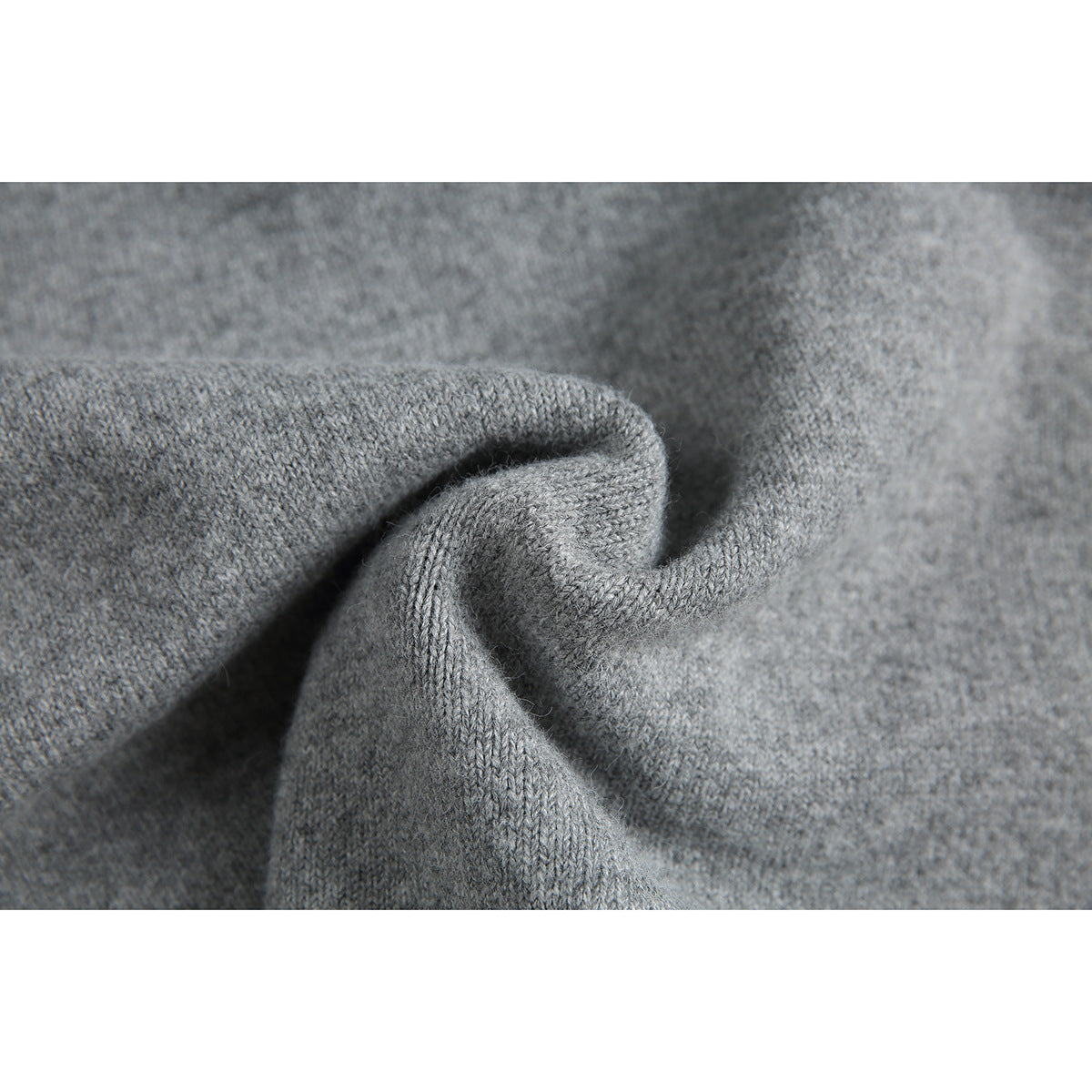 Close-up of gray sweater knit fabric gathered into a fold.