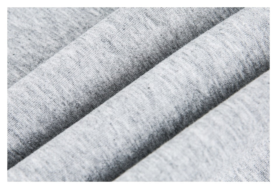 Close-up of gray heather knit fabric draped in soft folds, showing its surface texture.