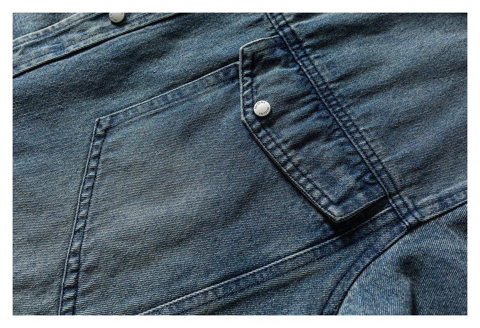 Close-up of a washed blue denim shirt front, showing a chest pocket and button placket.