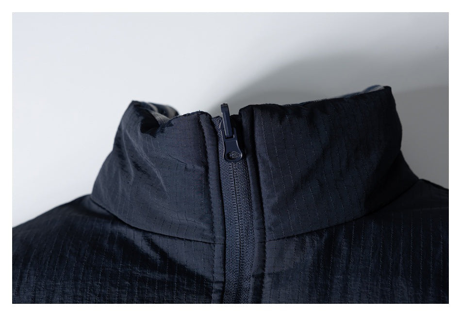 Close-up of the dark navy jacket's raised collar and front zipper.