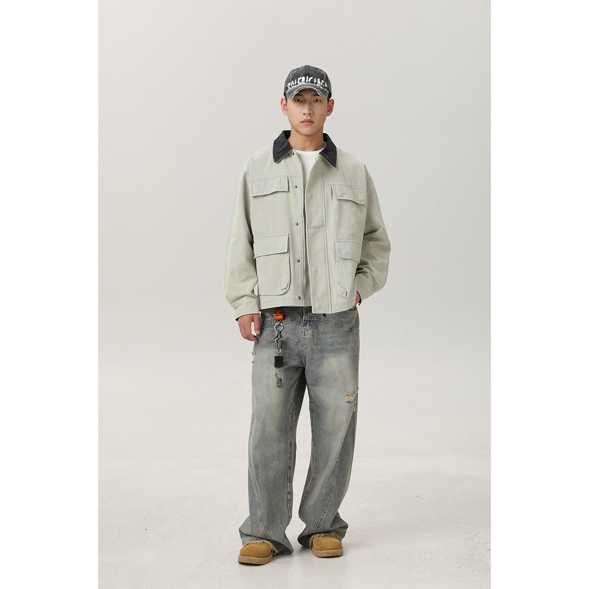 Full-length front view of a model wearing a pale sage utility jacket with a black collar and four flap pockets.