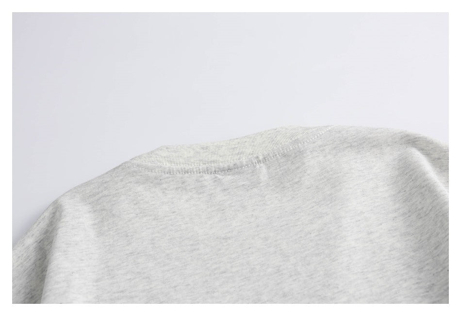 Close-up of the crew neckline and shoulder area of a light gray heather garment.