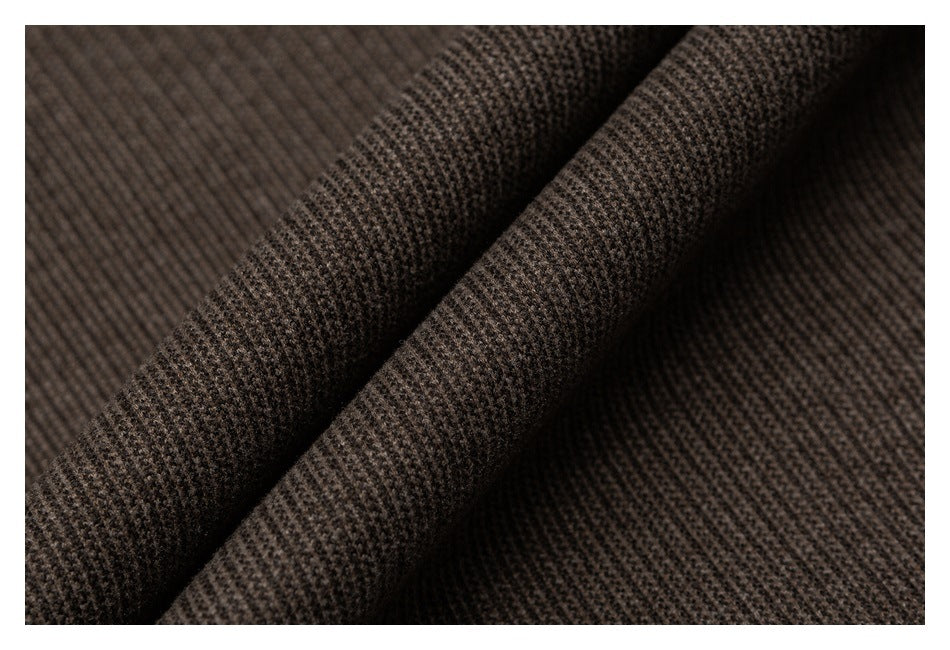Macro view of the brown garment's raised, finely patterned fabric texture.