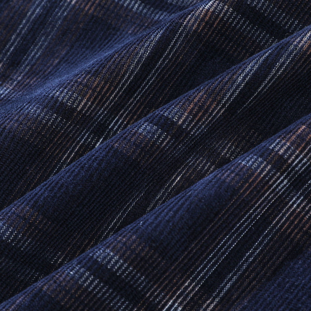 Close-up of the navy plaid fabric with raised folds and fine woven texture.