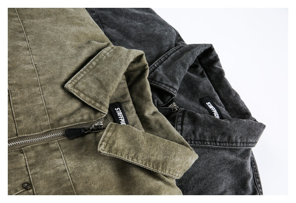 Close-up of olive-brown and charcoal jackets showing their collars, zippers, and sewn neck labels.