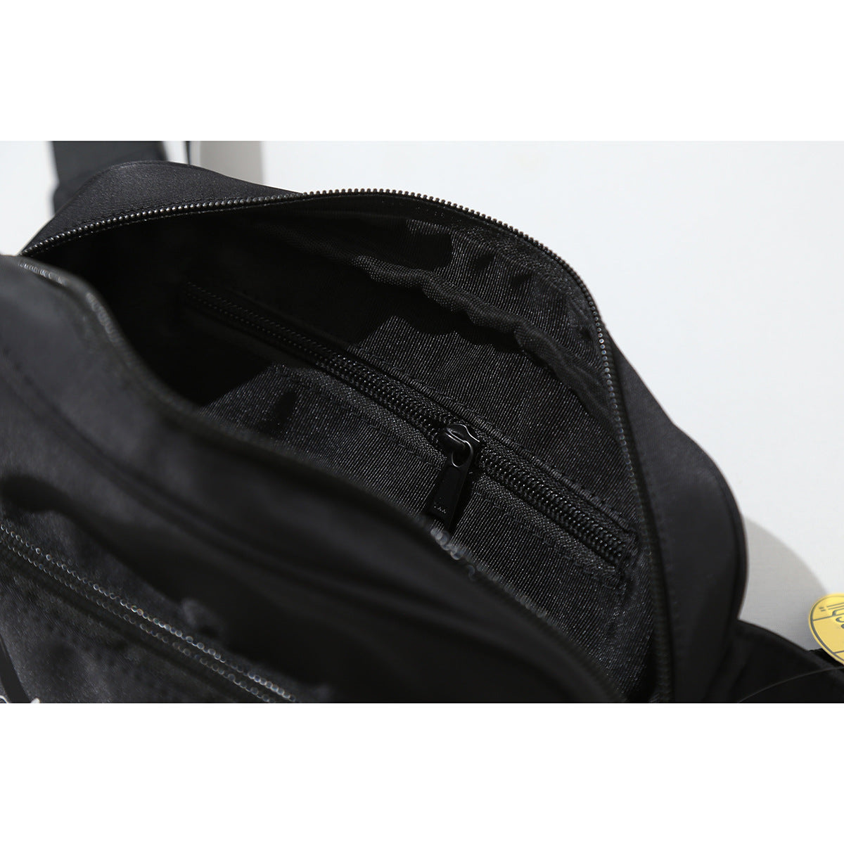 Open black bag showing its lined interior and an inner zip pocket.