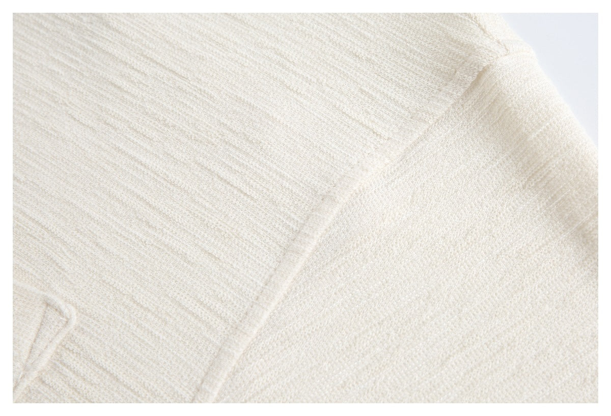 Close-up of a stitched seam on an ivory textured garment.