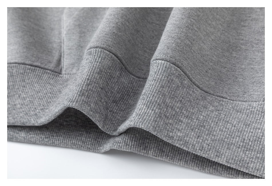 Close-up of the gray sweatshirt's ribbed hem and stitching.