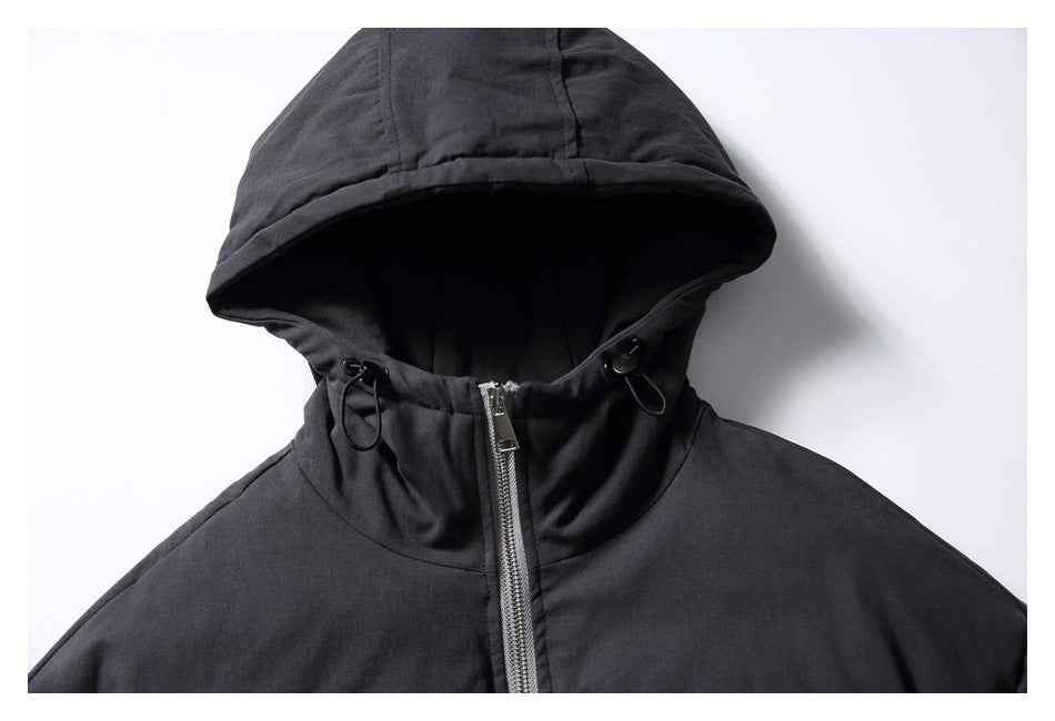 Close-up of the black jacket's hood, high collar, drawcord hardware, and front zipper.