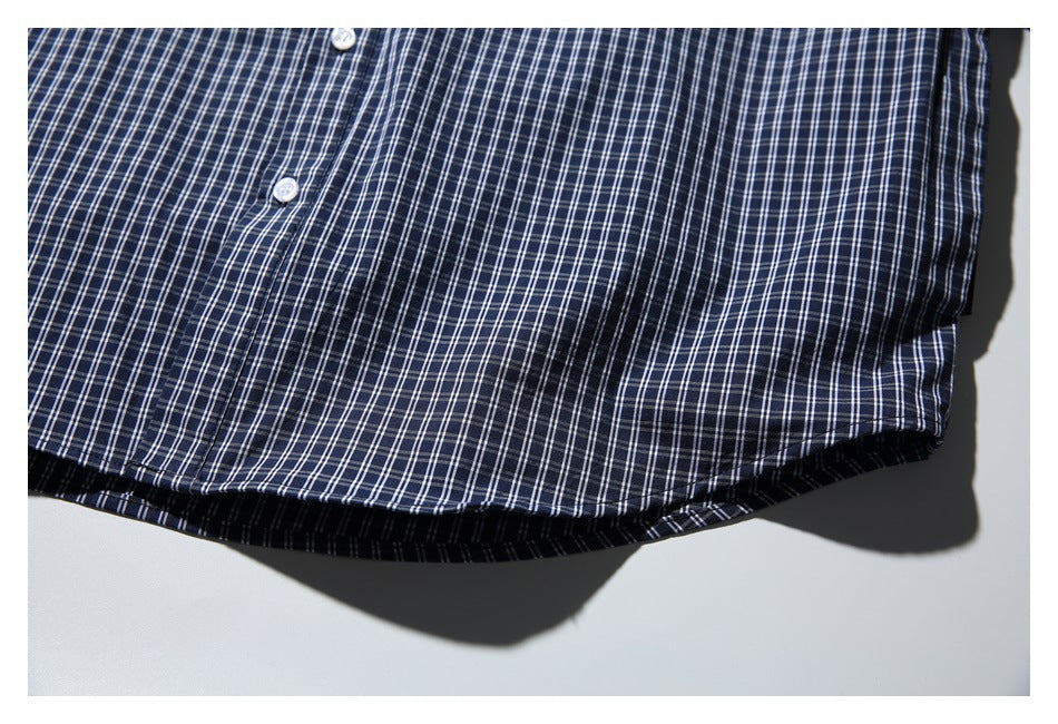 Close-up of the navy-and-white plaid shirt's lower front and curved hem.