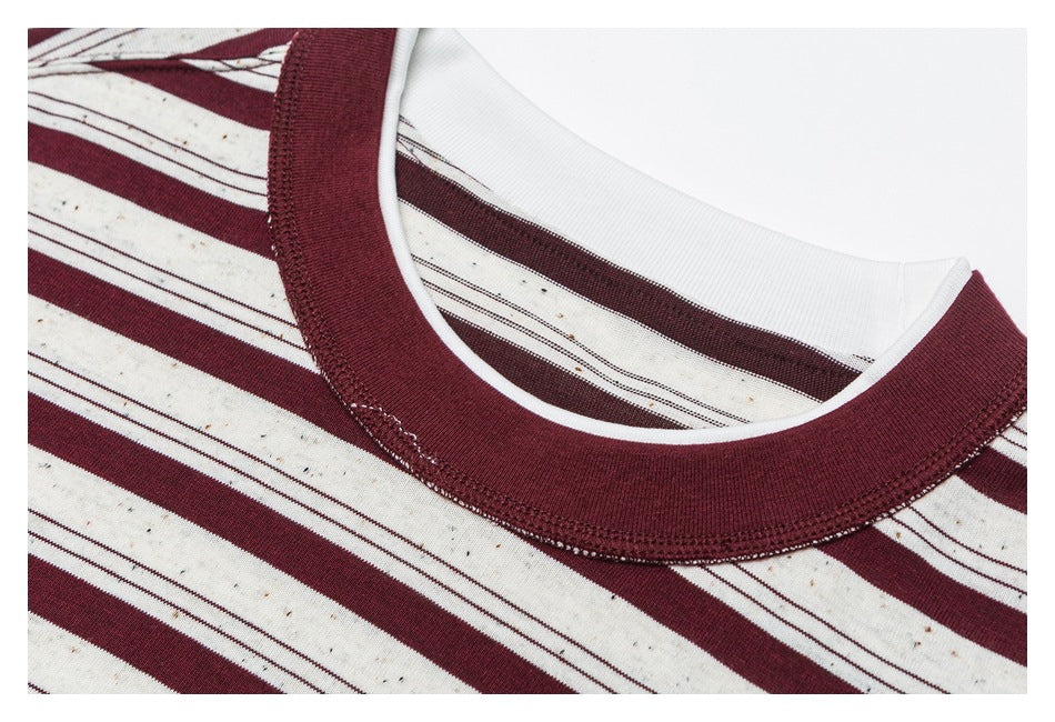 Close-up of a cream T-shirt with burgundy stripes and a burgundy ribbed crew neckline.