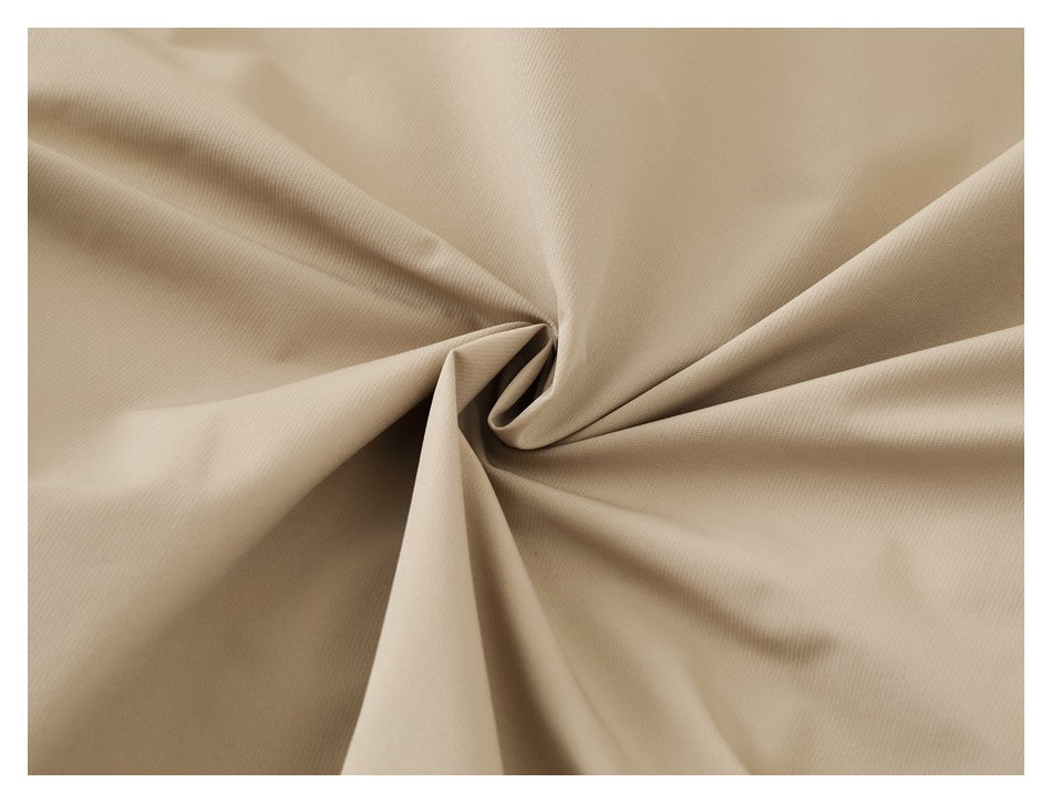 Close-up of beige fabric arranged in soft folds, showing its fine surface texture.