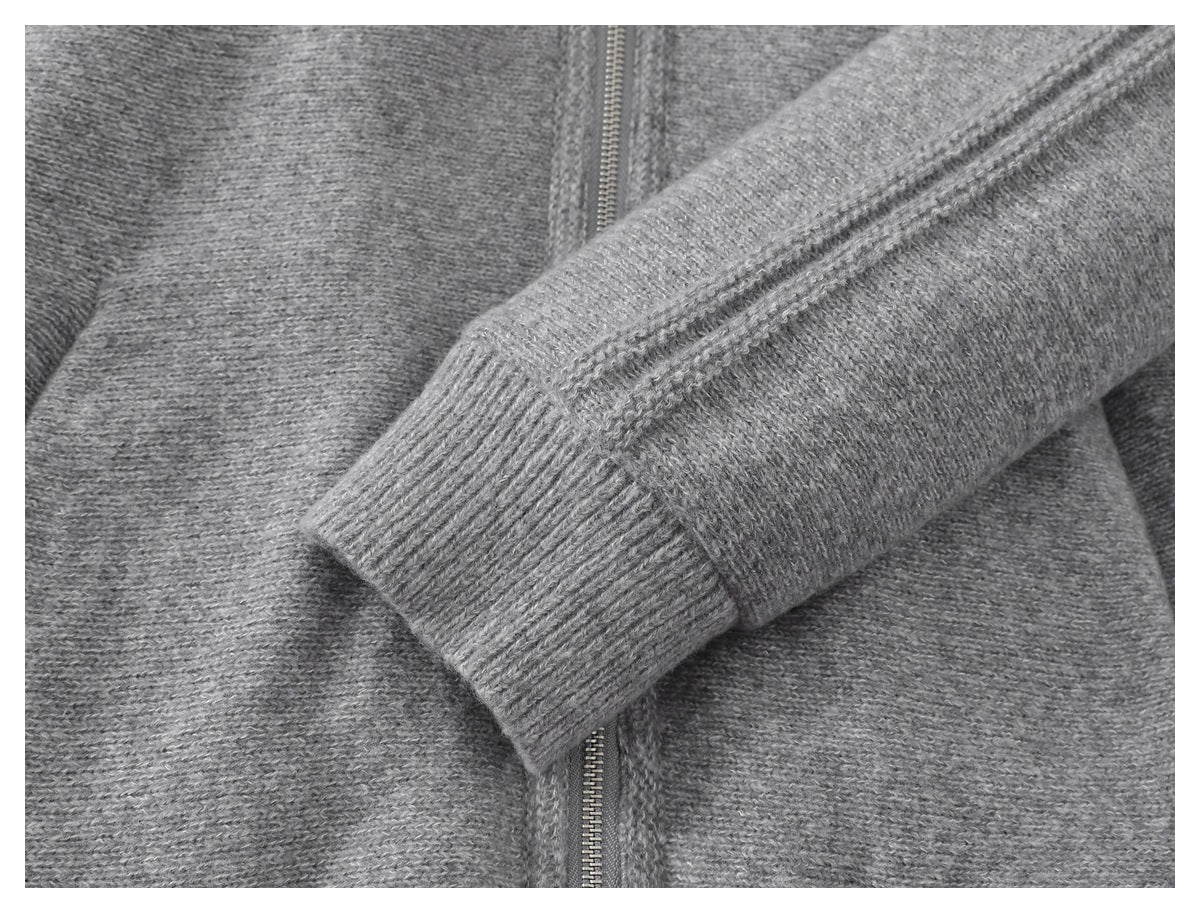 Close-up of a gray knit sleeve with a ribbed cuff laid across the garment.