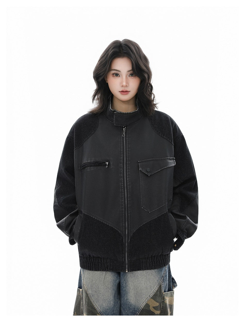 Model wearing a black color-block zip jacket with a stand collar and chest pockets, paired with loose jeans.