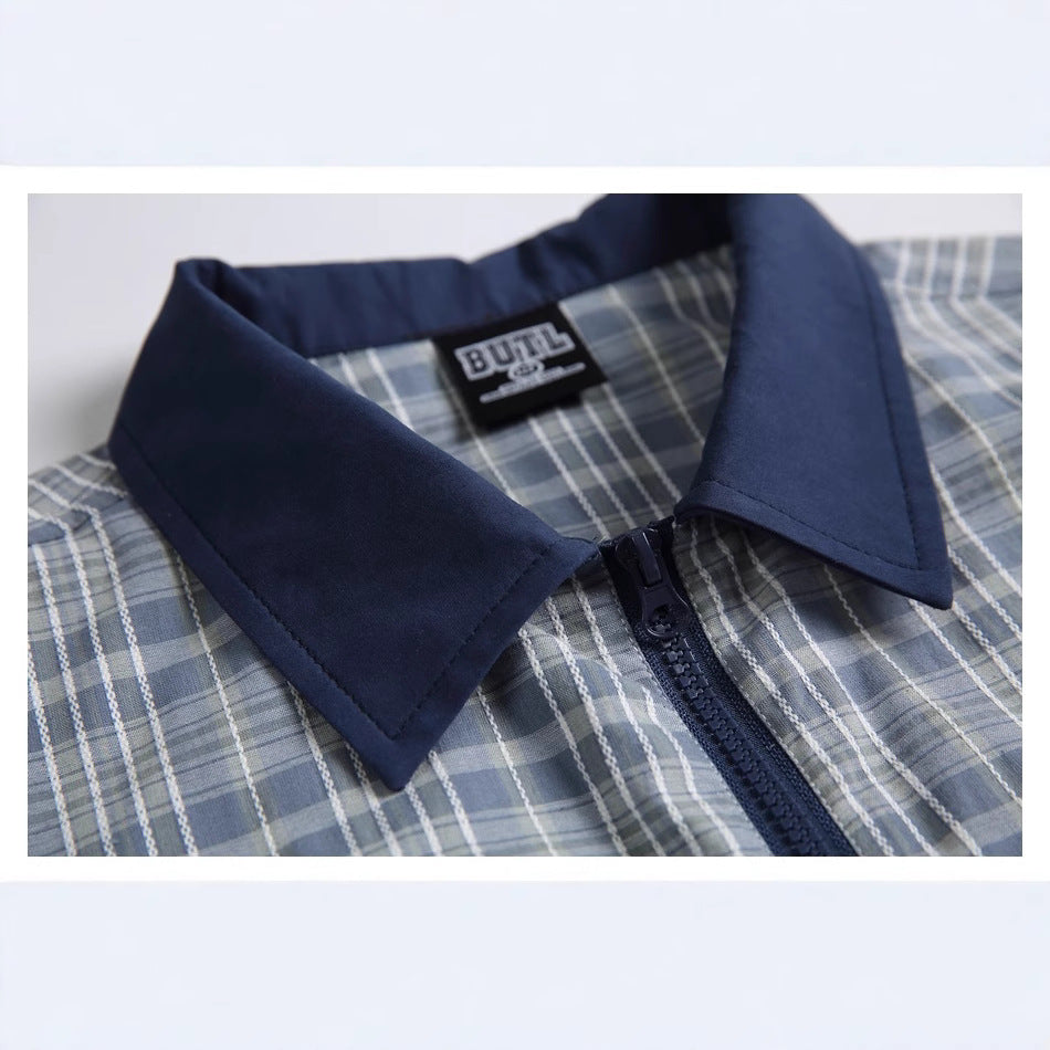 Close-up of the shirt's navy collar, zipper, plaid fabric, and sewn-in neck label.